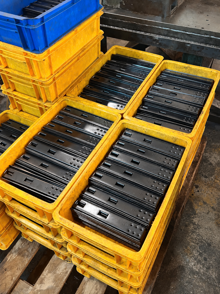 Precision-stamped metal components in production batches at Truc Lam, illustrating OEM metal manufacturing in Vietnam.