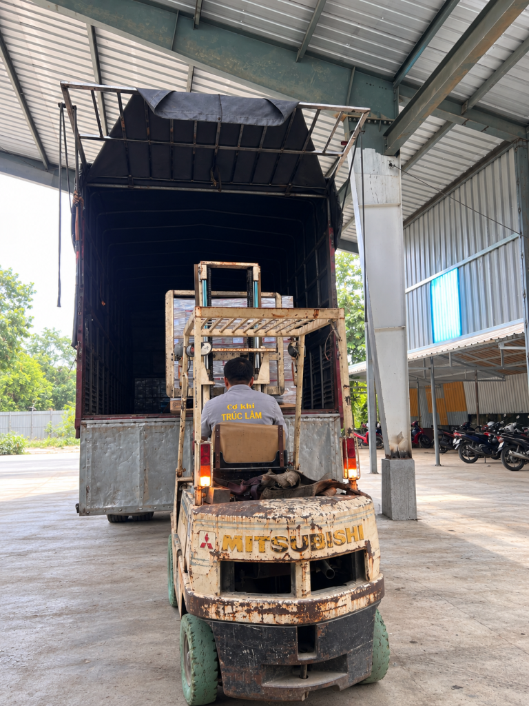 Truc Lam forklift operator loading packaged OEM products into a delivery truck at the manufacturing facility in Vietnam.